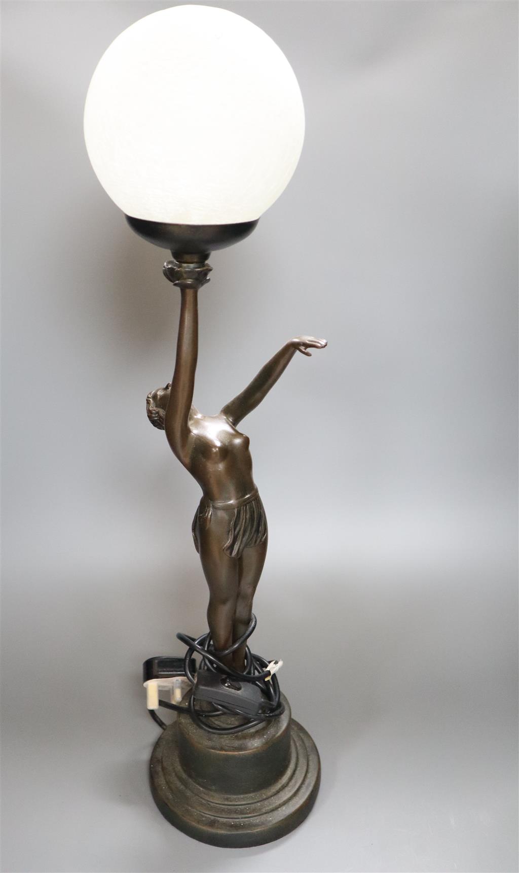 An Art Deco style bronzed resin figural table lamp, semi-nude female holding glass shade aloft, 66cm overall